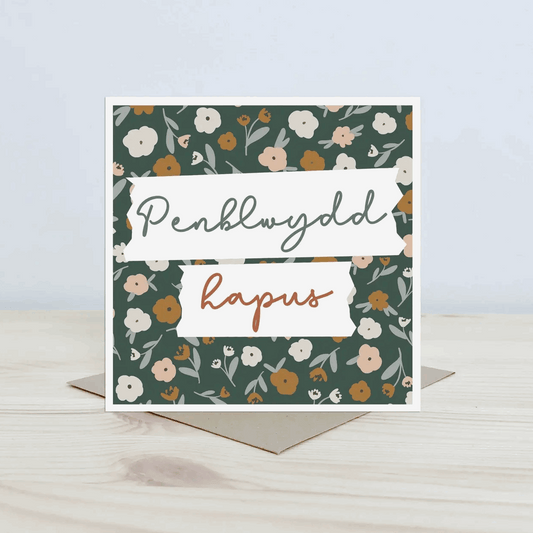 Penblwydd hapus Greeting card with floral pattern and text on a light surface